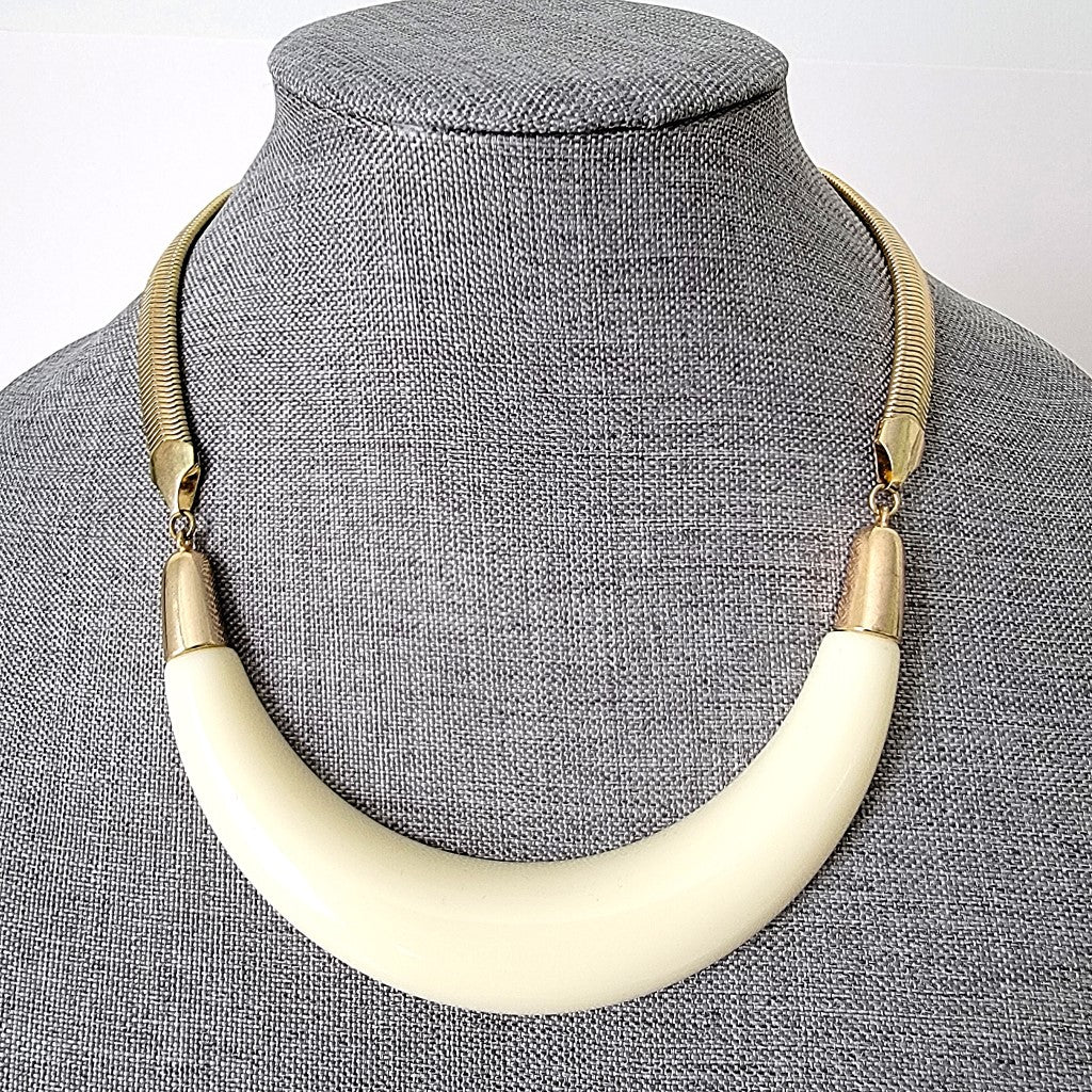 Cream acrylic statement necklace on display.