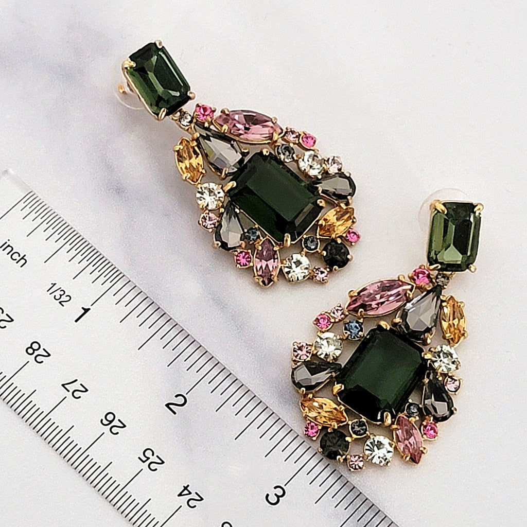 Chunky rhinestone earrings with a ruler.