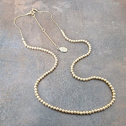 Skinny gold tone bead necklace.