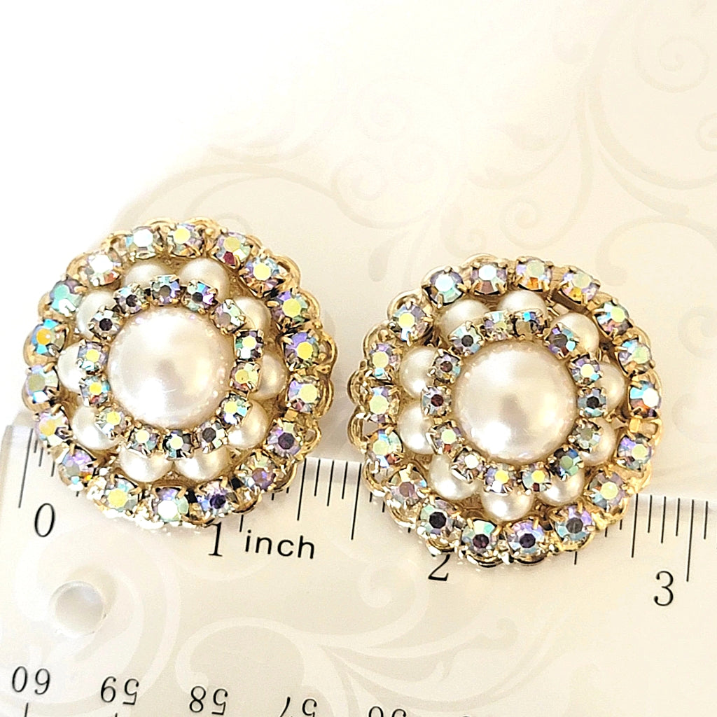 Vintage rhinestone earrings next to a ruler.