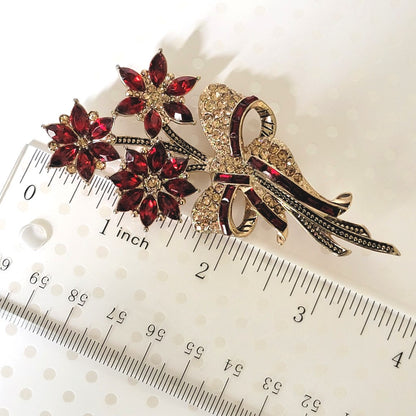 Avon poinsettia Christmas pin, shown next to a ruler.