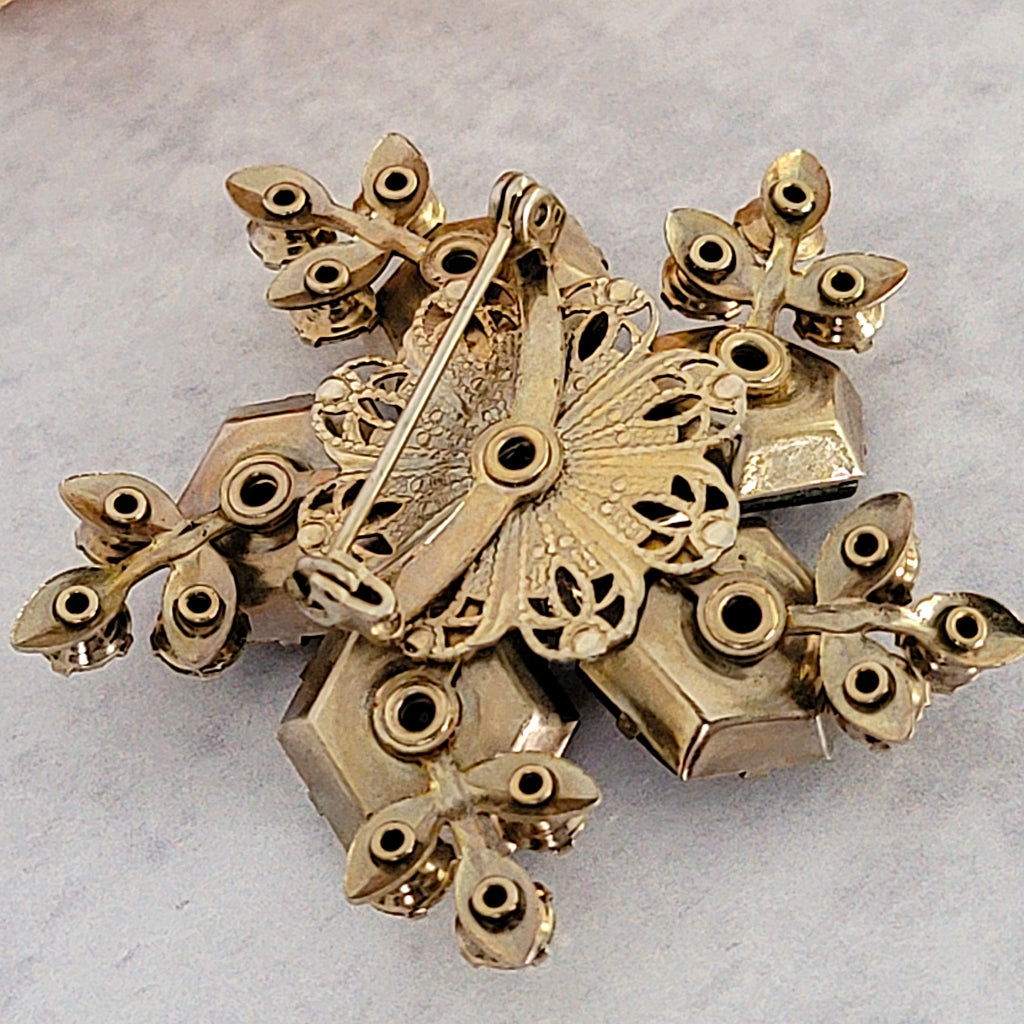 Gold tone riveted prong setting on the back of a vintage brooch.