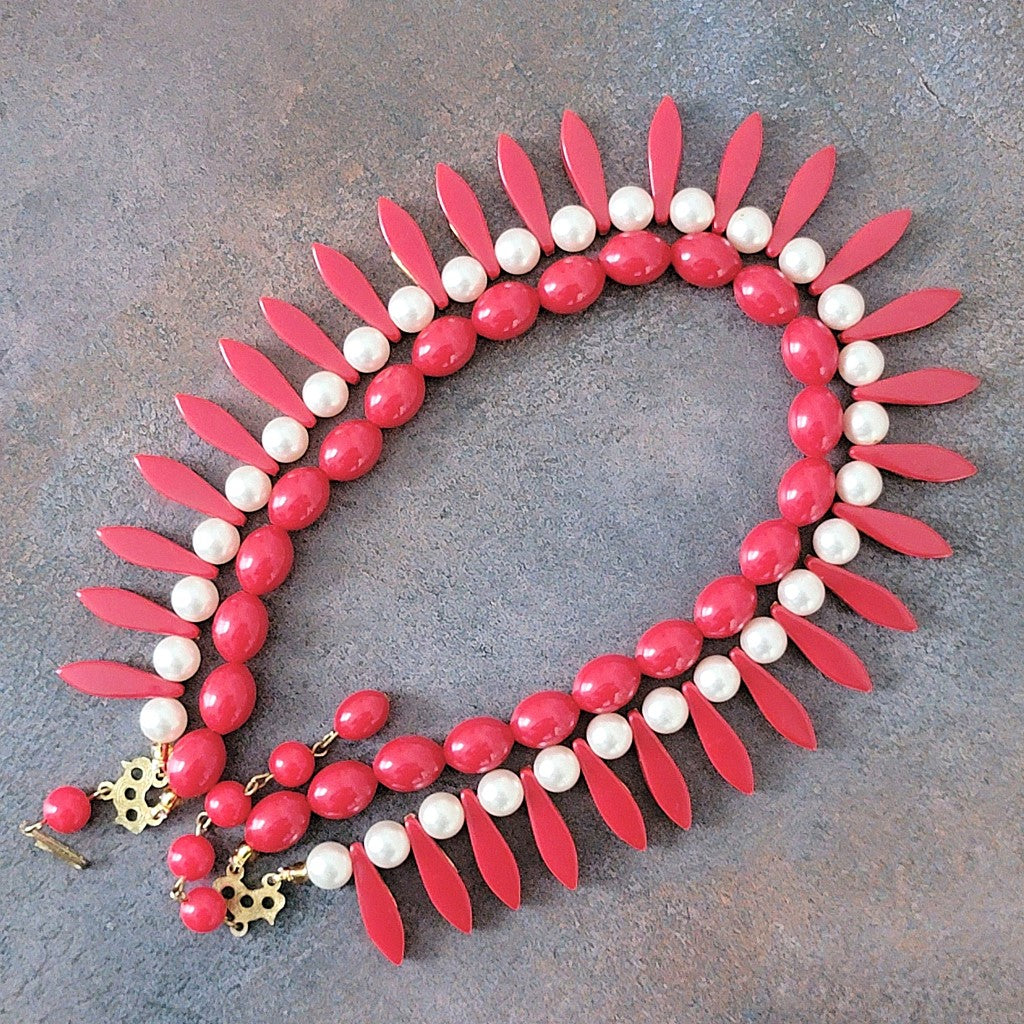 Back of red plastic spike beaded necklace.