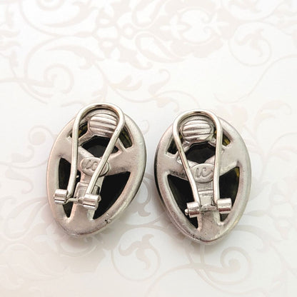 Back view of Liz Claiborne beetle earrings, showing clips and signature marks.