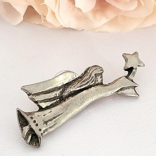 Pewter angel pin holding a star.