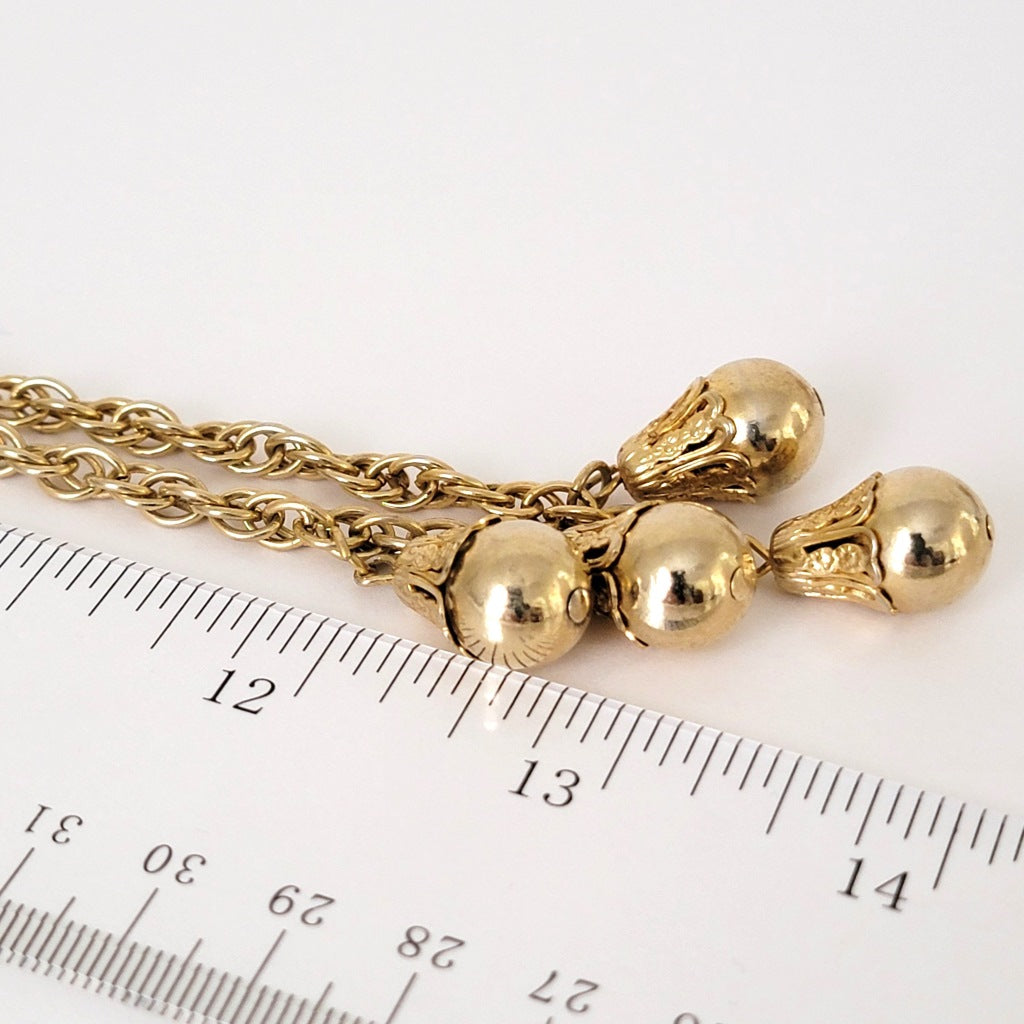 Gold tone bead dangles with ruler.