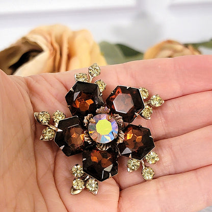 Brown and yellow vintage crystal brooch in hand.