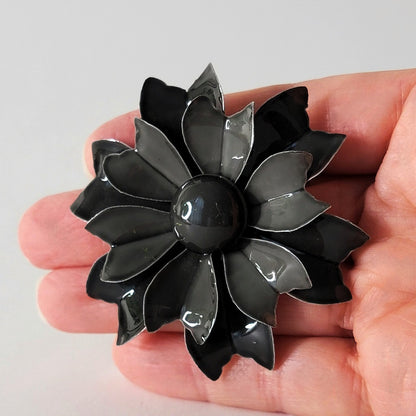 Black flower pin in hand.