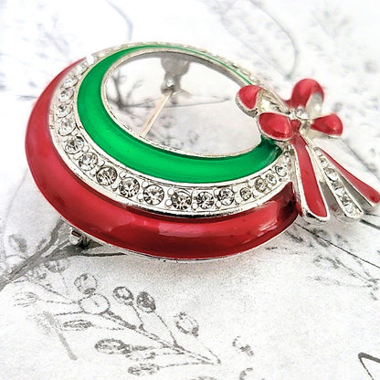 Red and green enamel on rhinestone Christmas wreath brooch.