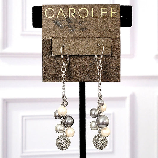 Long dangling faux pearl earrings, by Carolee, hanging on card.