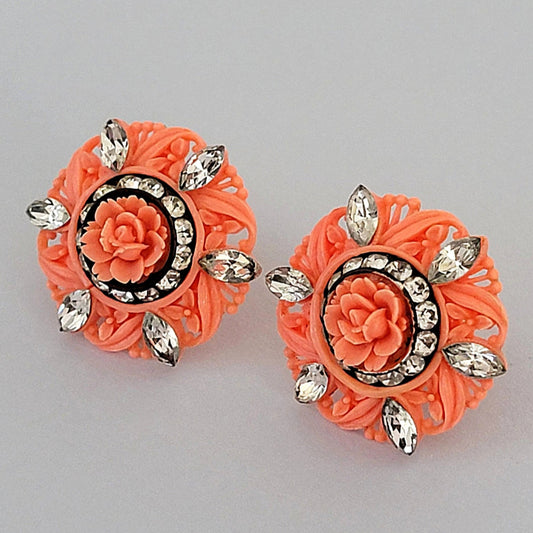 Coral color plastic flower earrings with clear rhinestones. 