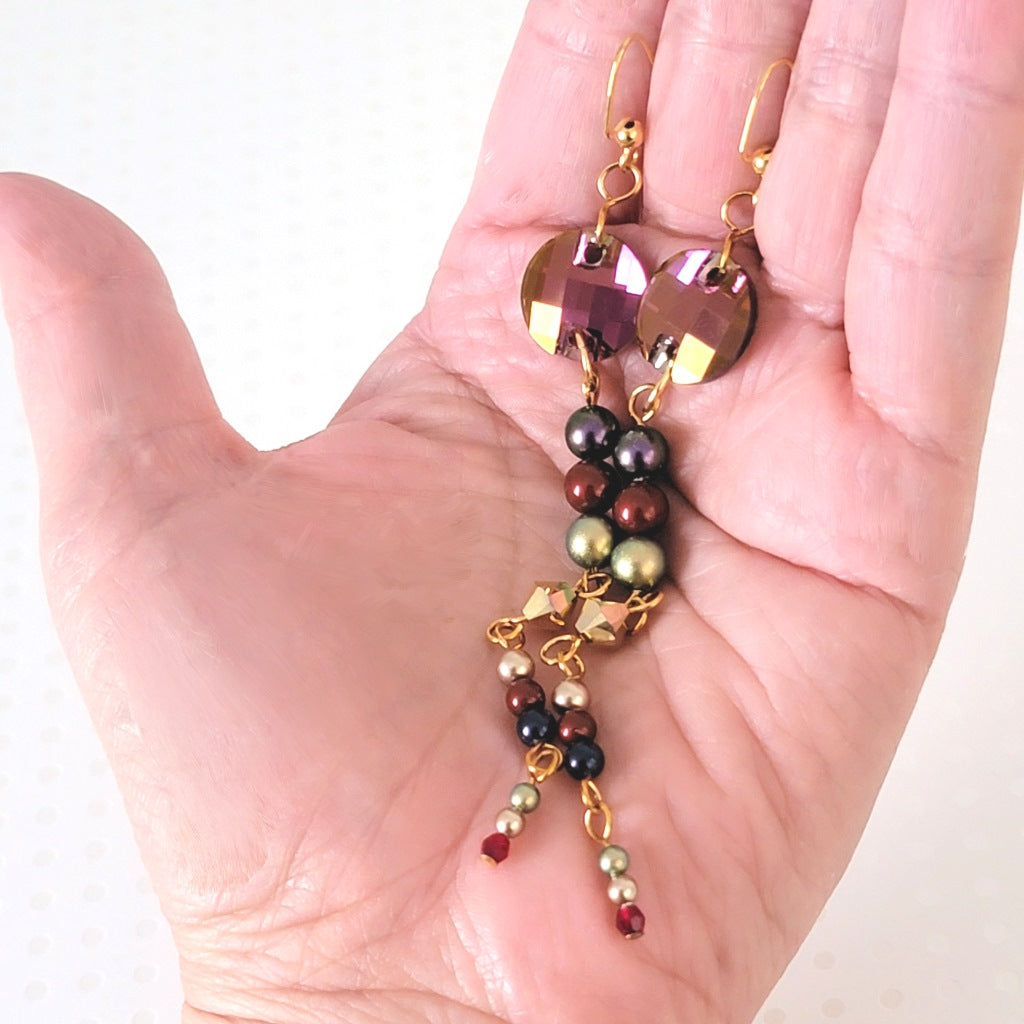 Long crystal and faux pearl earrings, in hand, for size comparison.