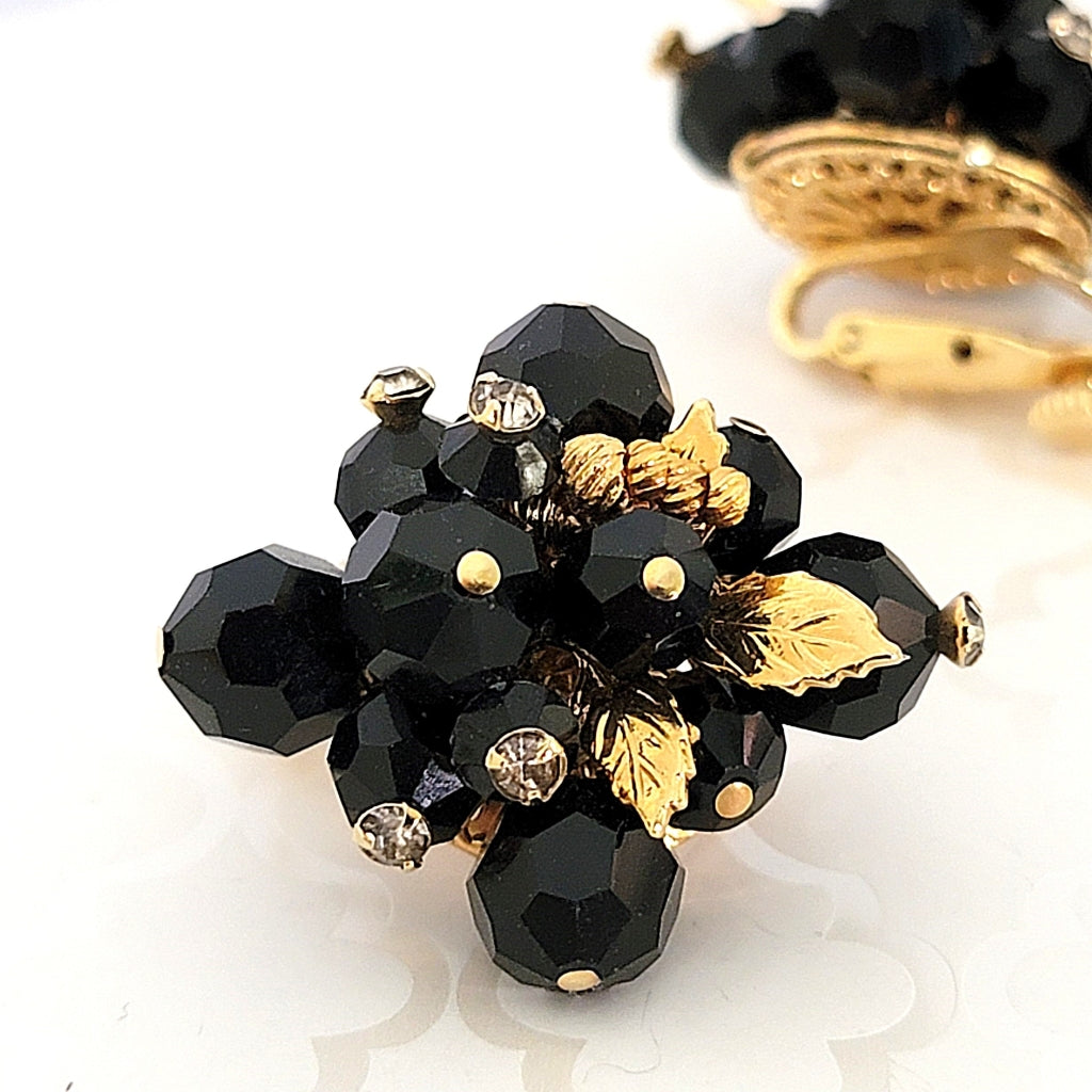 Black glass beads, rhinestones and gold tone leaves.