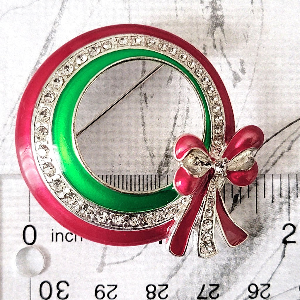 Red and green wreath pin with ruler.