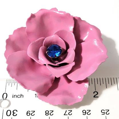 Large pink and blue flower pin next to a ruler.