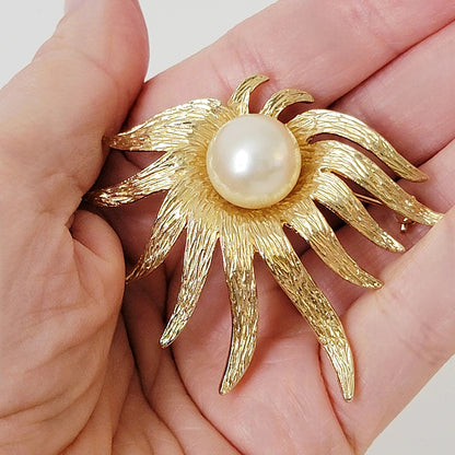 Vintage gold tone Judy flower pin in hand.