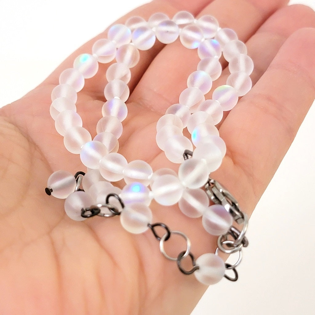 Frosted glass bead necklace in hand.