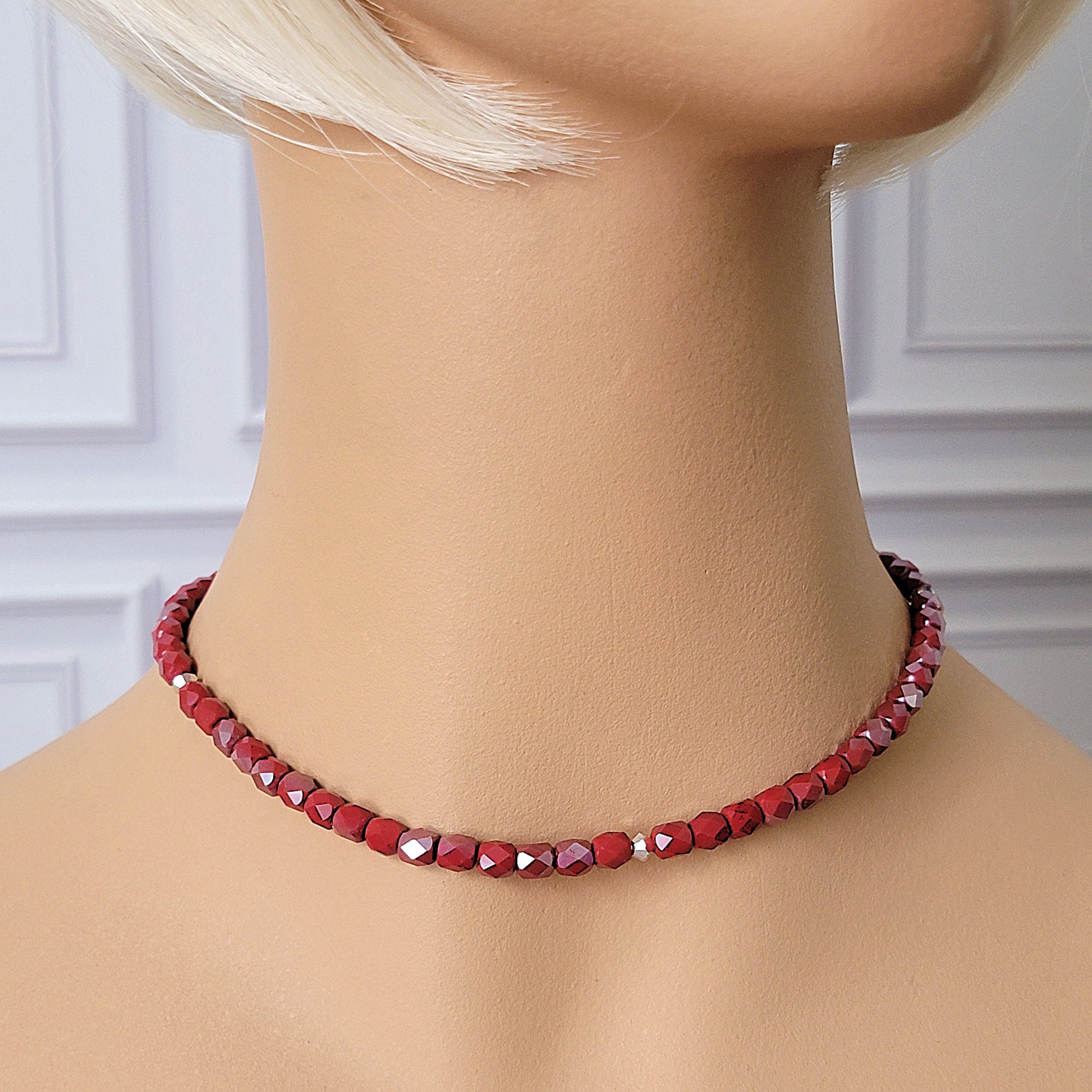 Red beaded necklace on a mannequin.