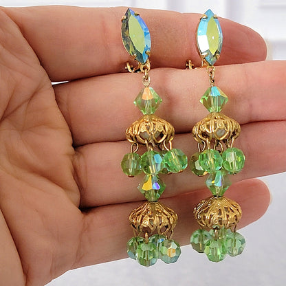 Light green vintage long dangle earrings in hand.