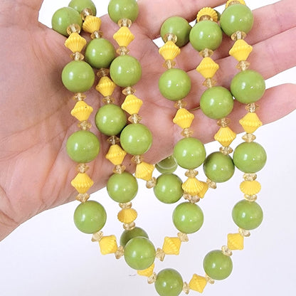 Green and yellow beads in hand.