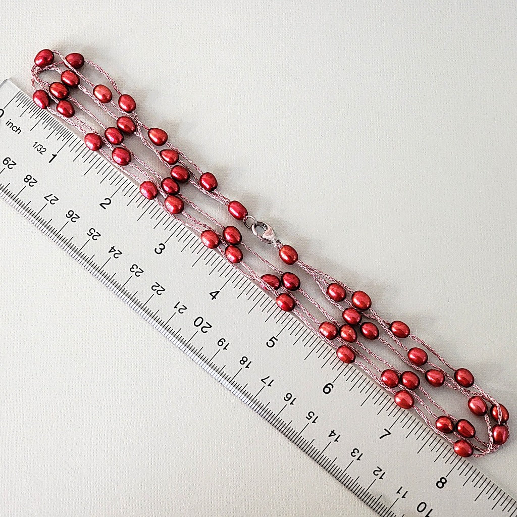 Red pearl necklace with ruler.