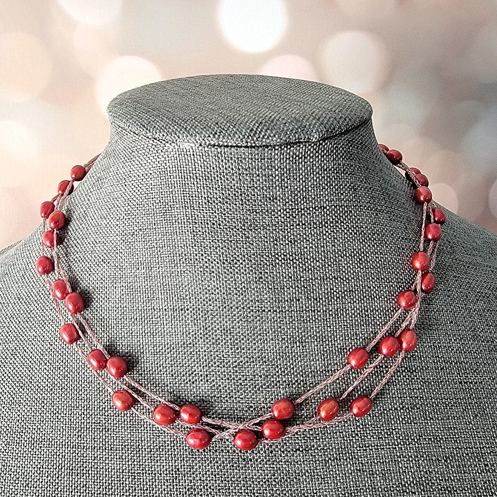 Red pearl necklace on display stand.