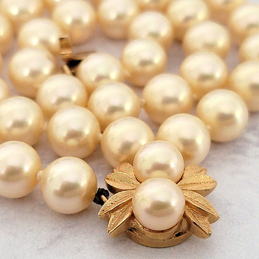 Cream glass pearls with gold tone leaf box clasp.