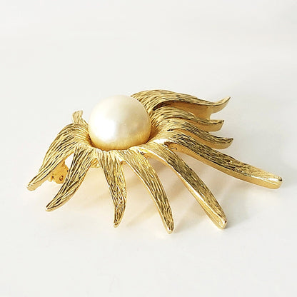 Textured gold tone petals on a vintage flower pin.