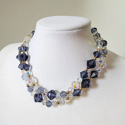 Long blue beaded necklace, doubled on a display stand.