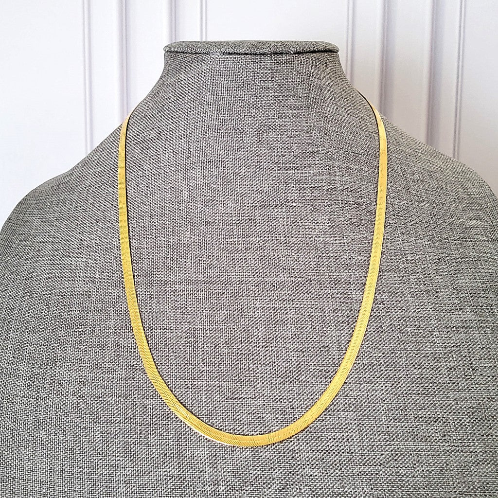 Gold tone snake chain on display.