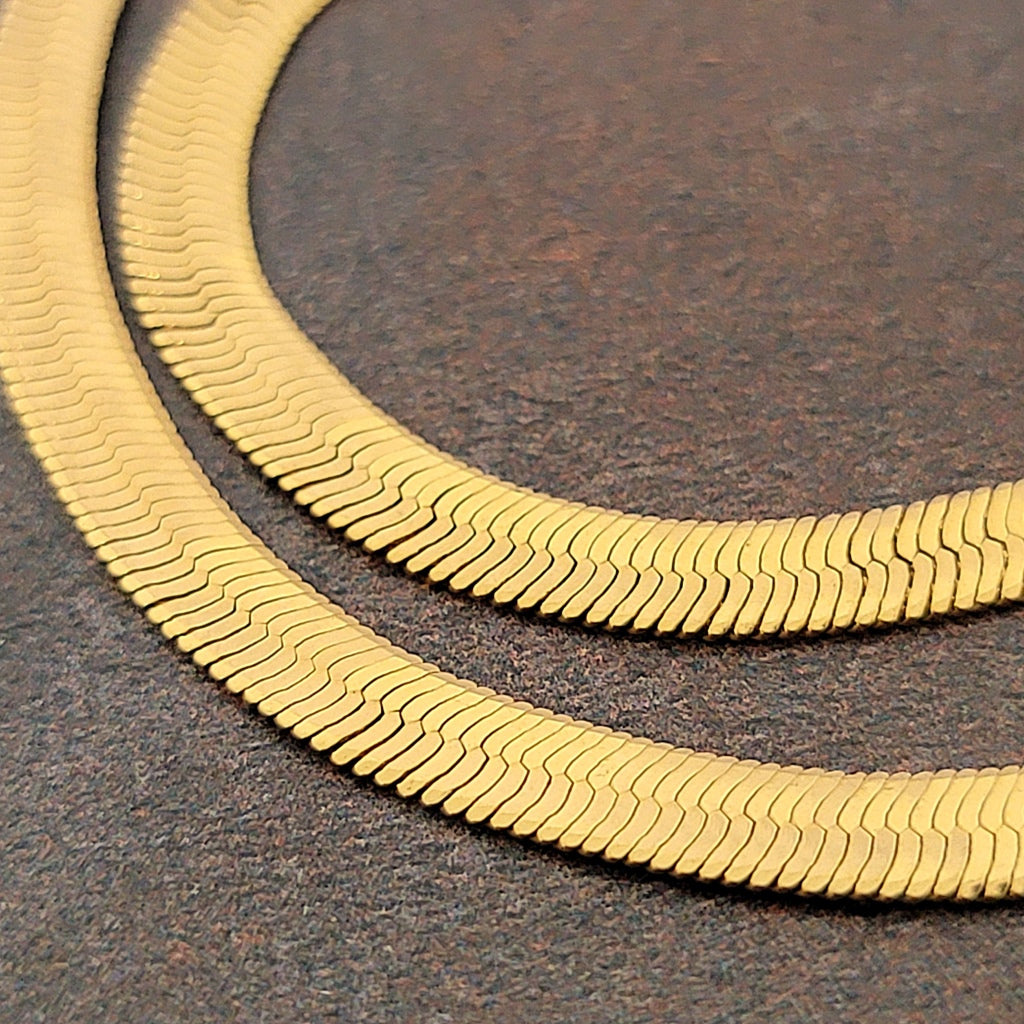 Flat gold tone snake chain.