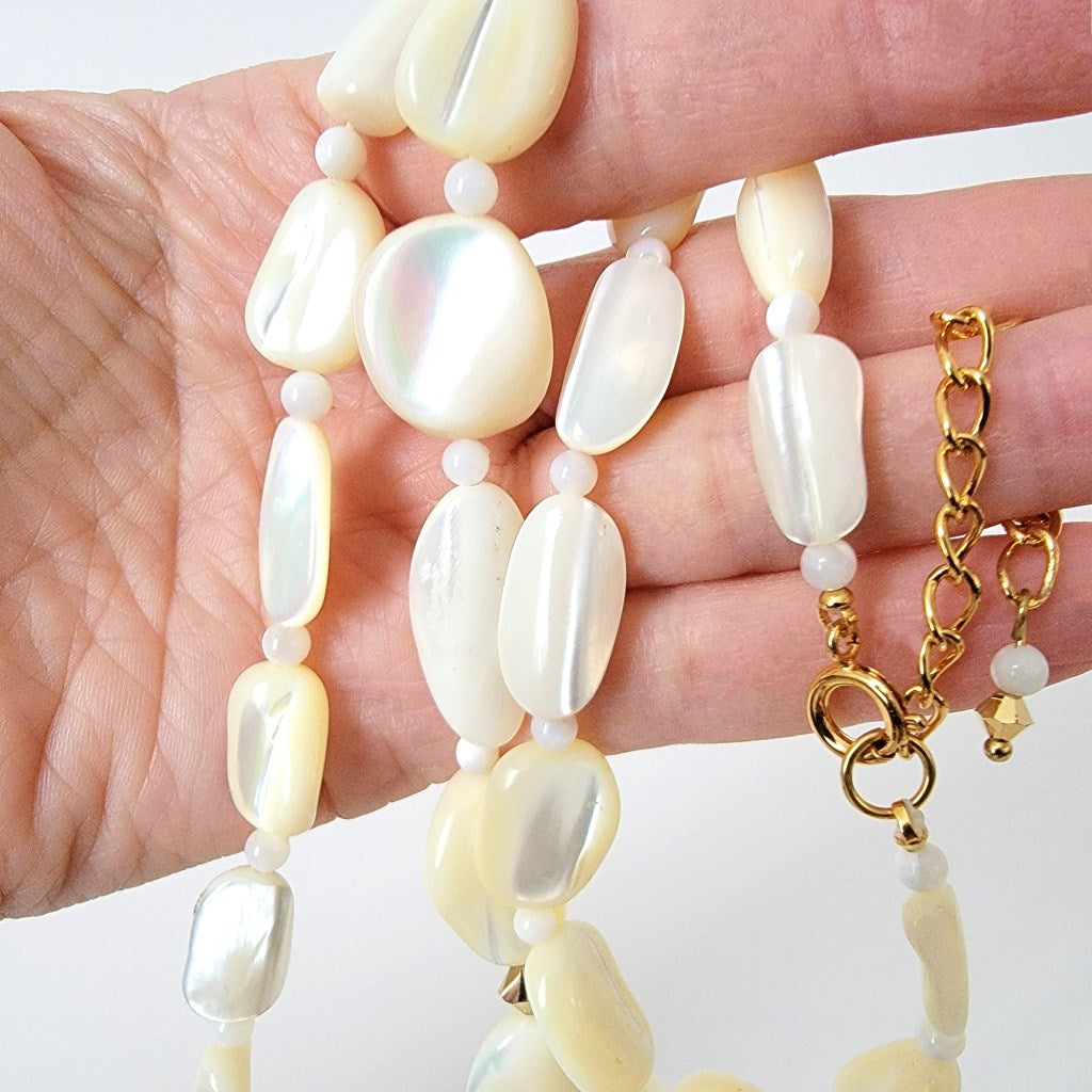 Shell necklace in hand.