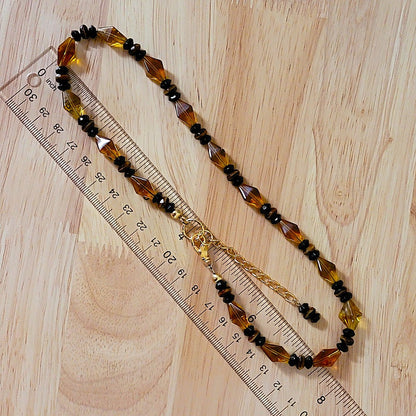 Amber glass necklace with ruler.