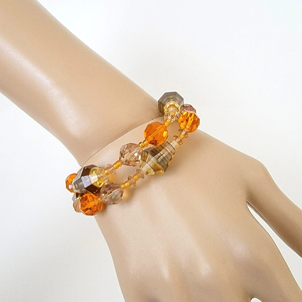 Two strand orange glass beaded bracelet on wrist.