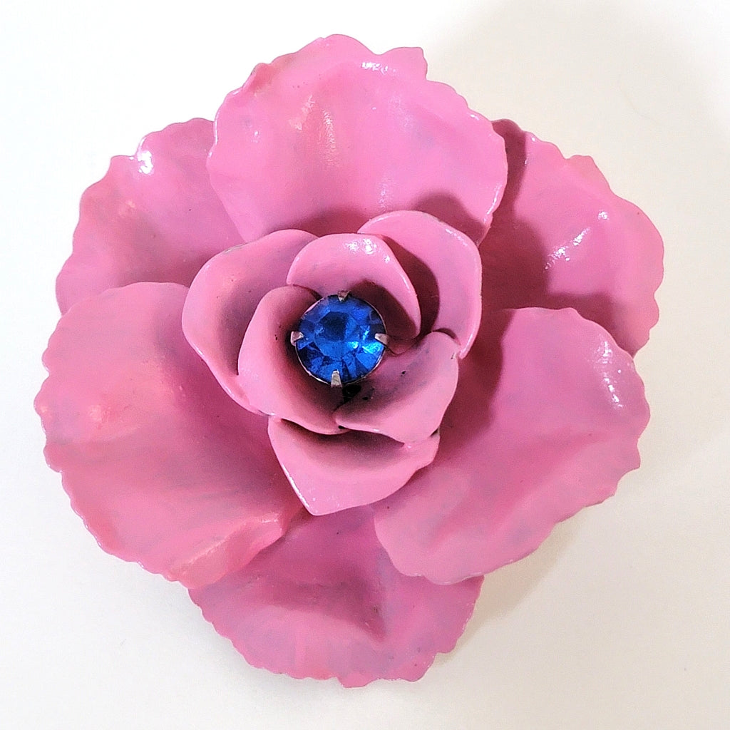 Pink enamel flower pin with blue center rhinestone.