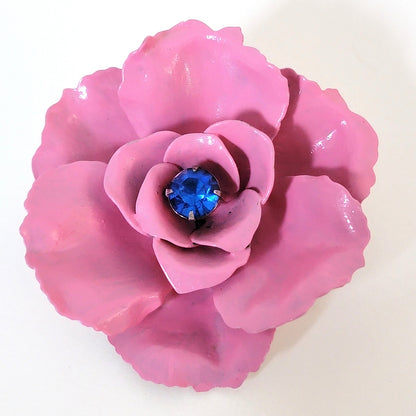 Pink enamel flower pin with blue center rhinestone.