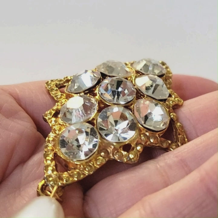 Rhinestone dangle brooch.