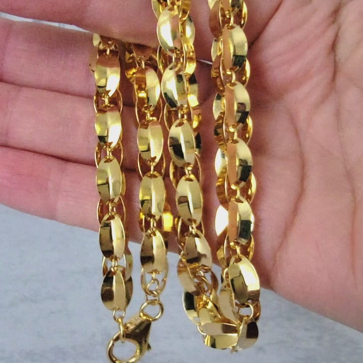 Gold tone necklace in hand.