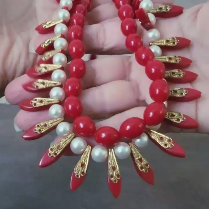 Red vintage beaded necklace in hand.