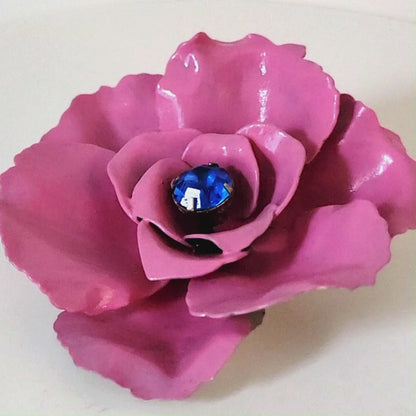 Vintage pink enamel rose pin with a blue lucite center.