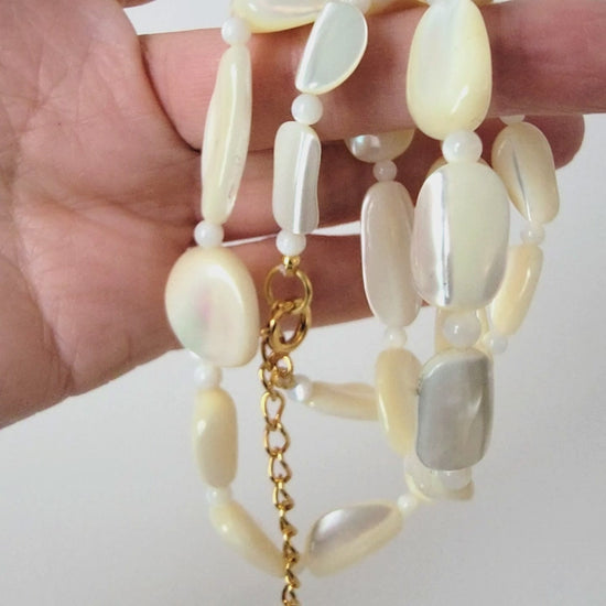 Mother of pearl beaded necklace in hand.