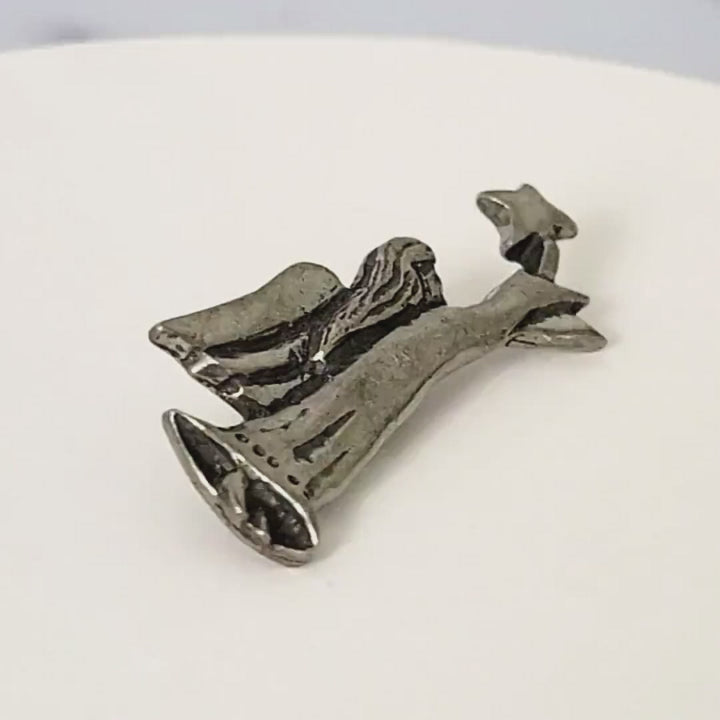 Pewter angel pin, in folk art style, flying while carrying a star.