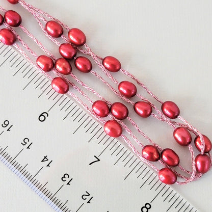 Red dyed pearl beads with ruler.