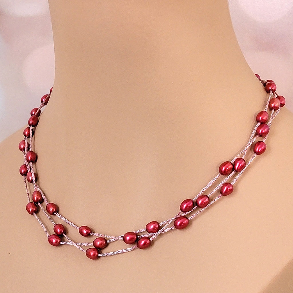 Red floating pearl necklace on mannequin.