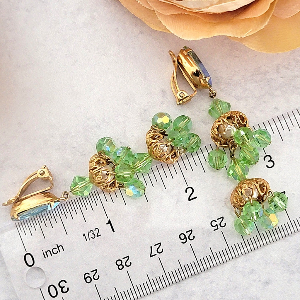 Vintage green chandelier earrings next to a ruler.