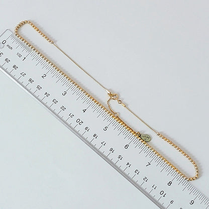 Gold tone minimalist necklace with a ruler.