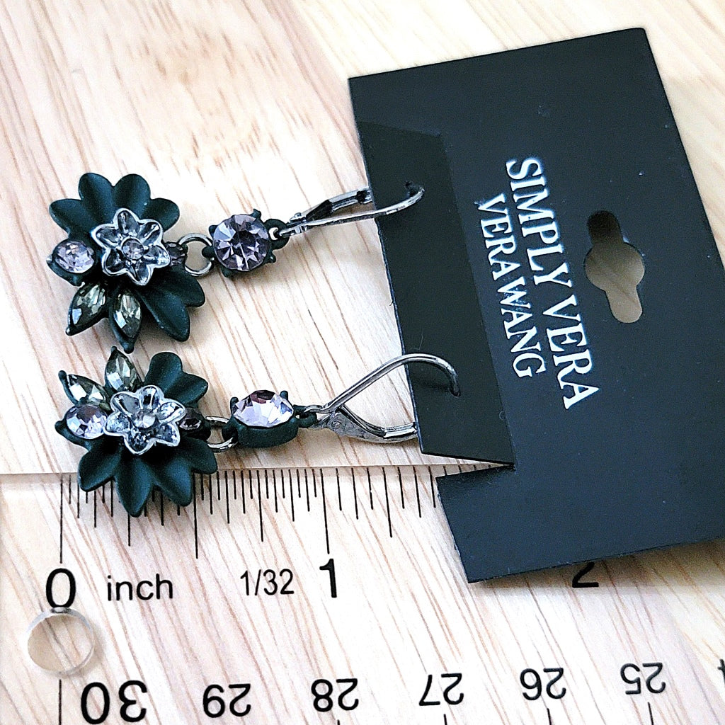 Rhinestone earrings next to a ruler.