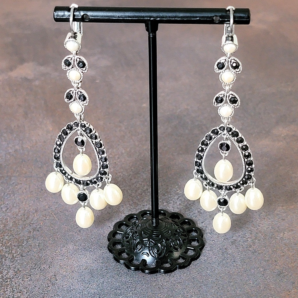 Long faux pearl earrings on stand.