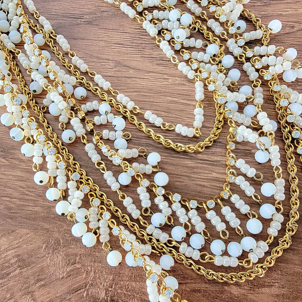 White beads and gold tone chains.