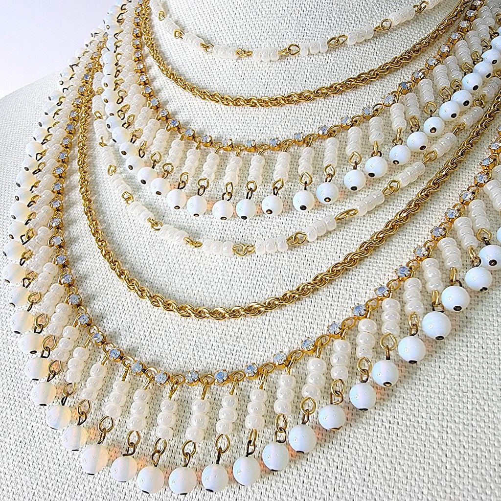 Six strands of white glass beads and rhinestones.